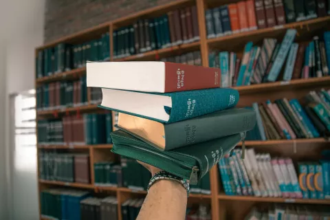 Picture of some books with a library in the background