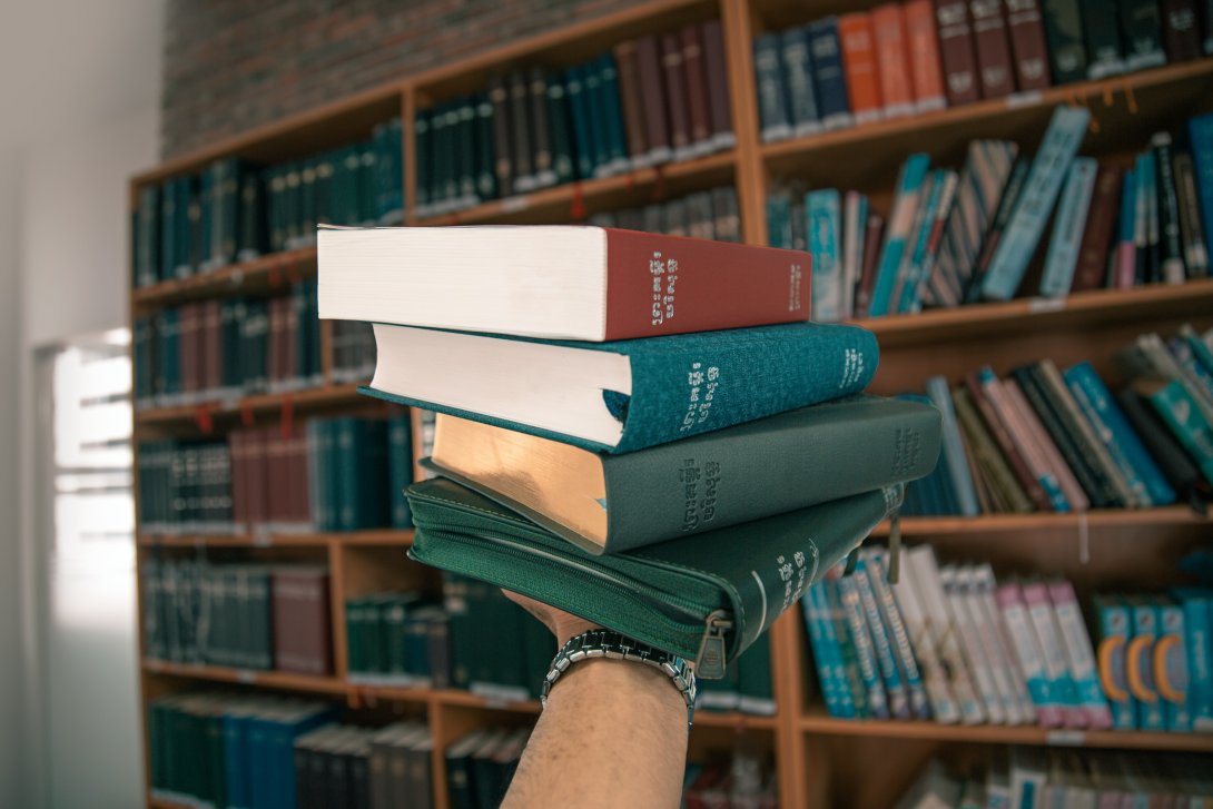 Picture of some books with a library in the background