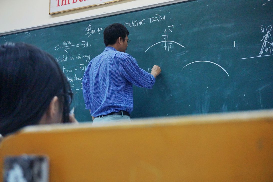 Picture of a professor writing on a blackboard