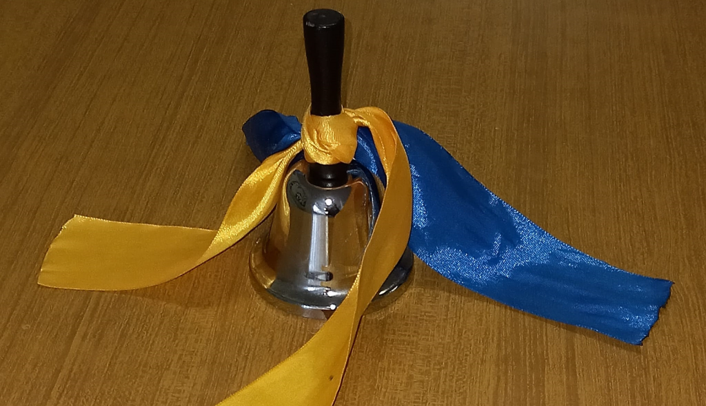 Picture of a bell with a ribbon with the Ukrainian colors