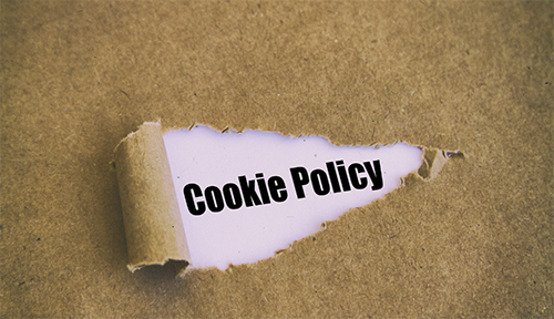 Cookie policy script visible through a tear in a brownish jute fabric