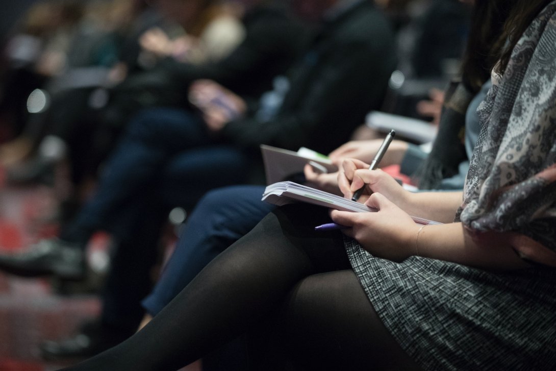 Photographs of people sitting down taking notes on notepads