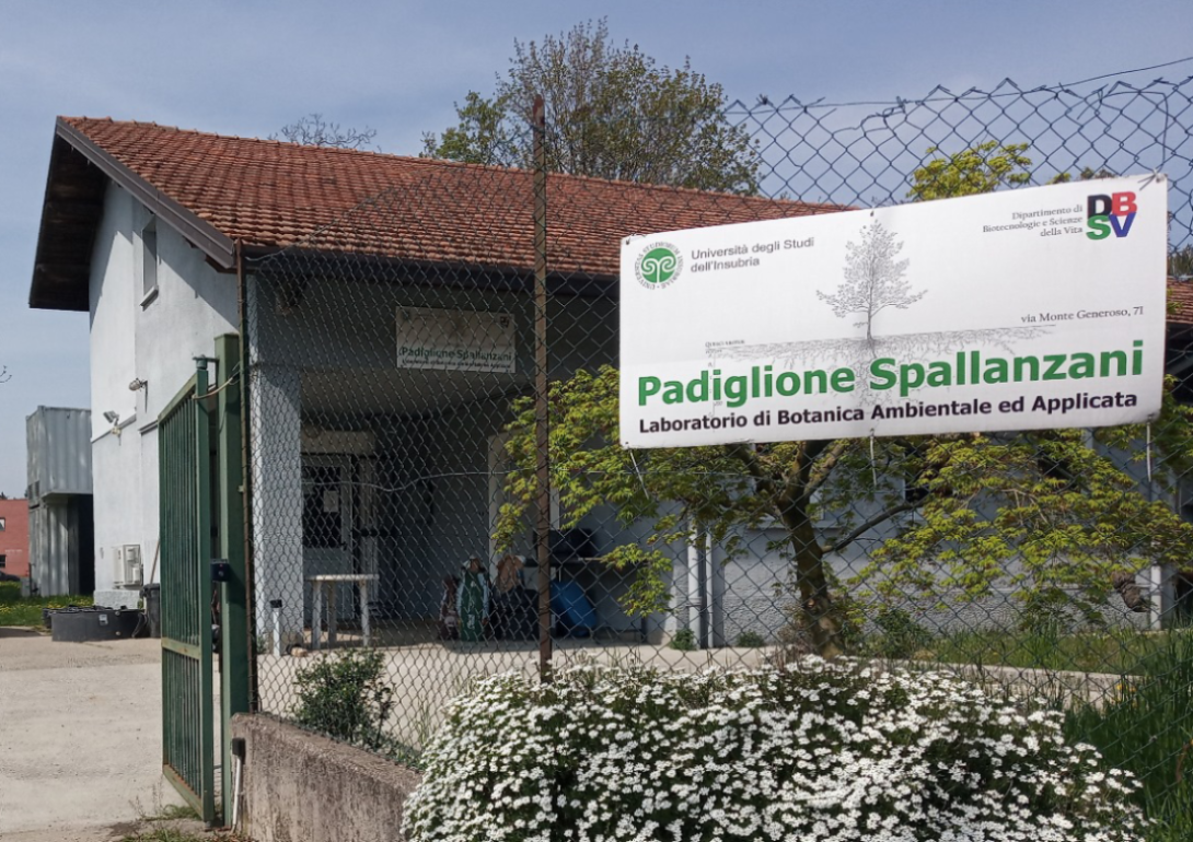 Entrance to the building, with a fence and flowering bush, as well as a sign reading "Spallanzani Pavilion"