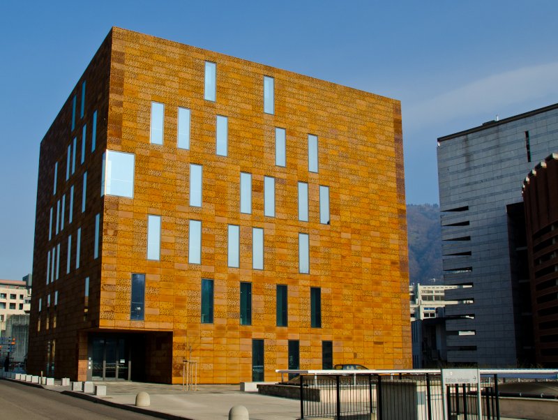 A rust-coloured building, pavements